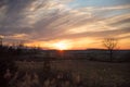 Cloudy Winter Sunset over Wild Grass and Fields with Blue Sky in Royalty Free Stock Photo