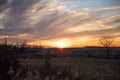 Cloudy Winter Sunset over Wild Grass and Fields with Blue Sky in Royalty Free Stock Photo
