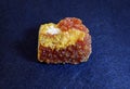 Clouse-up of yellow orpiment from the eastern Ukraine, on a blue background