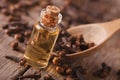 Clove oil in a bottle close-up on the table, rustic Royalty Free Stock Photo