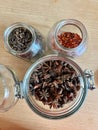 Clove spices, pepper and anise in a mason jar over wicker background