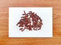 Clove. Syzygium aromaticum plant flower buds. Dried spice sample on paper wooden background. Royalty Free Stock Photo