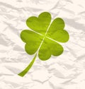 Clover with four leaves on crumpled paper