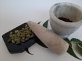 Cloves and Cardamom with mortar grinder on a plain white background