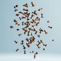 Cloves floating against light blue background creating a dynamic visual effect Royalty Free Stock Photo
