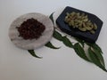 Cloves and Cardamom with mortar grinder on a plain white background