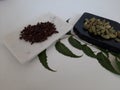 Cloves and Cardamom with mortar grinder on a plain white background