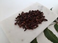 Cloves and Cardamom with mortar grinder on a plain white background