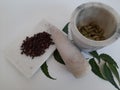 Cloves and Cardamom with mortar grinder on a plain white background
