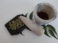 Cloves and Cardamom with mortar grinder on a plain white background