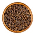 Cloves, dried aromatic flower buds, in a wooden bowl