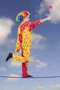 Clown as a tightrope walker with flower