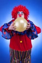 Clown with a ballon in hands on blue background Royalty Free Stock Photo