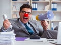 Clown businessman angry in the office with a megaphone Royalty Free Stock Photo