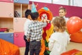 Clown with cheerful children play counting game