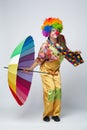 Clown with colorful umbrella on white Royalty Free Stock Photo