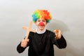 A clown dressed as a Catholic pastor with a cross and a rosary. The concept of blasphemy and ridicule of religion Royalty Free Stock Photo