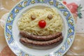 Clown face with sausages, tomato, pasta and hazelnuts Royalty Free Stock Photo