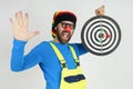 The clown holds a target in his hands, shows the result of dart shooting, with the second hand shows a gesture - class