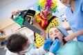 Clown from horror with chainsaw in dental clinic