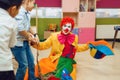 Clown with joyful children playing tug of war