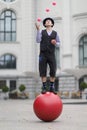 The clown juggles with pink balls