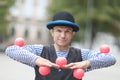 The clown juggles with pink balls