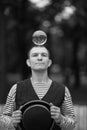 A clown man holds a transparent magic ball