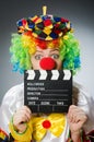 Clown with movie clapper in funny concept Royalty Free Stock Photo