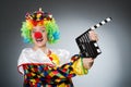 Clown with movie clapper in funny concept Royalty Free Stock Photo