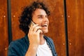 Clsoe up portrait of young happy man smiling, standing next to modern building and talking on mobile phone. Young male student Royalty Free Stock Photo