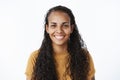 Clsose-up shot of joyful good-looking friendly african-american woman with long curly hair and white broad smile gazing