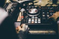 Club DJ playing mixing music on vinyl turntable at party