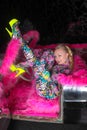 Club party blonde girl in acid anime style spandex catsuit with mirror car with pink fur ready for crazy clubbing life