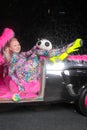 Club party blonde girl in acid anime style spandex catsuit with mirror car with pink fur ready for crazy clubbing life Royalty Free Stock Photo