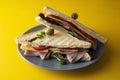 Club sandwich with ham isolated. Toasted double panini with ham, cheese fresh vegetables. Yellow background Royalty Free Stock Photo