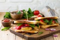 Sandwich with tomatoes, cheese, crispy chicken nuggets and arugula. Delicious fresh homemade club sandwich with chicken on a Royalty Free Stock Photo