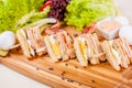 Club sandwiches with egg, ham, bacon, vegetables on wooden board Royalty Free Stock Photo