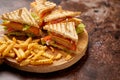 Club sandwiches served on a wooden board. With hot French fries Royalty Free Stock Photo