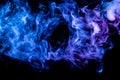Clubs of colored smoke of blue and pink color on a black isolated background in the form of clouds from the vape Royalty Free Stock Photo