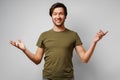 Clueless young man gesturing i don`t know against grey background Royalty Free Stock Photo