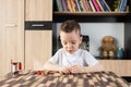 Cute boy assembling toys at his table