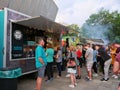 People stay in line to buy fast food at food trucks