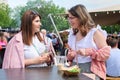 Two beautiful young girls talking at a fast food table