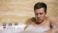 Clumsy man accidentally dropping phone into water taking bath with foam, fail
