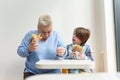 Clumsy white woman and her little son eating fast food. Mother and son enjoying their lunch in Greek cafe Royalty Free Stock Photo