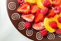Cluse-up Fruit salad of apricots strawberries and raspberries on a plate. Top view