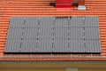 Cluster of eighteen brand new solar panels mounted on top of renovated office building new roof surrounded with snow fence Royalty Free Stock Photo