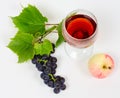 The cluster of grapes and apple lie near a wine glass with brand Royalty Free Stock Photo