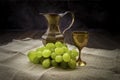 Cluster of grapes with a jug of wine on the canvas towel Royalty Free Stock Photo